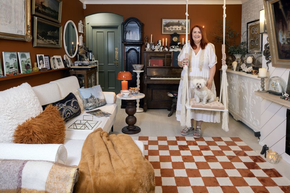 Emma Edmonds in her living room with her Maltese Terrier Maxi. The colour scheme is white with tobacco and rust as accent colours. The rug is from Kukoon. Photo: Tony Gavin